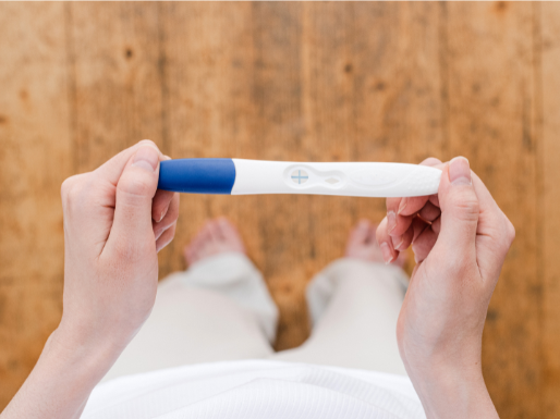 Consulta inicial de pré-natal com gestante, médico explicando exames e cuidados no início da gravidez.